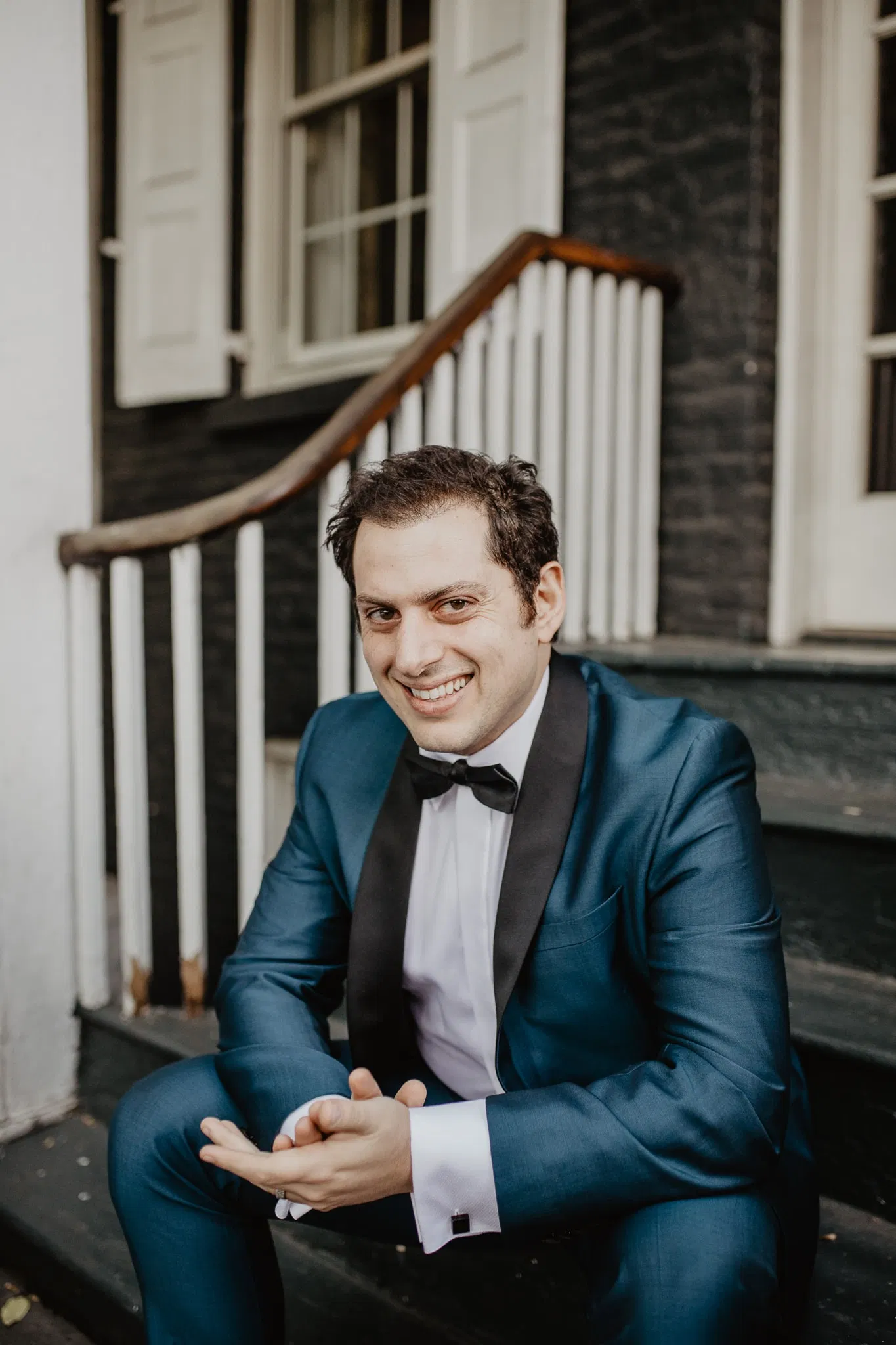Close up of groom sitting on steps in NYC on wedding day by Jessy Herman Photo