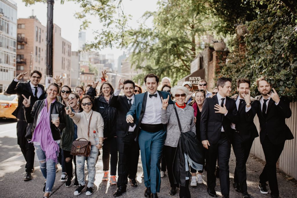 Groom, groomsmen, and large group of people in NYC on wedding day