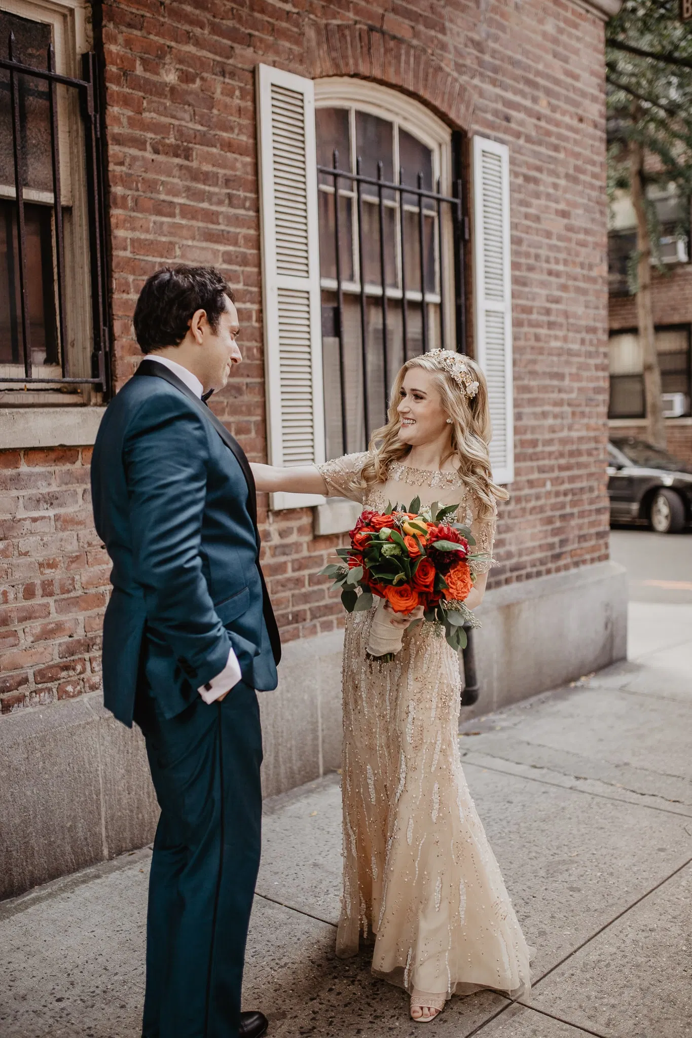 Bride fixes grooms suit jacket during first look on their new york city wedding day