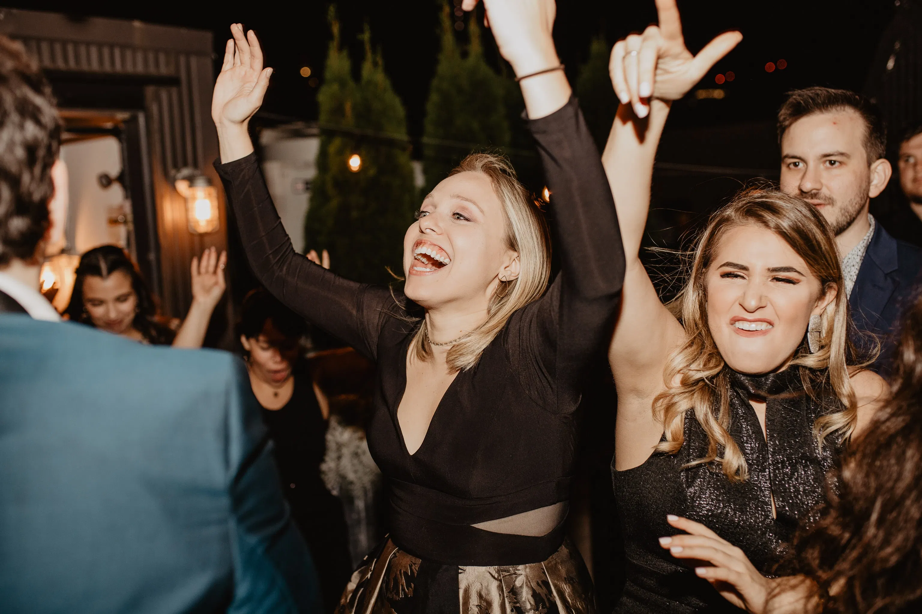 Woman smiling with hands in the air during a new york city wedding reception