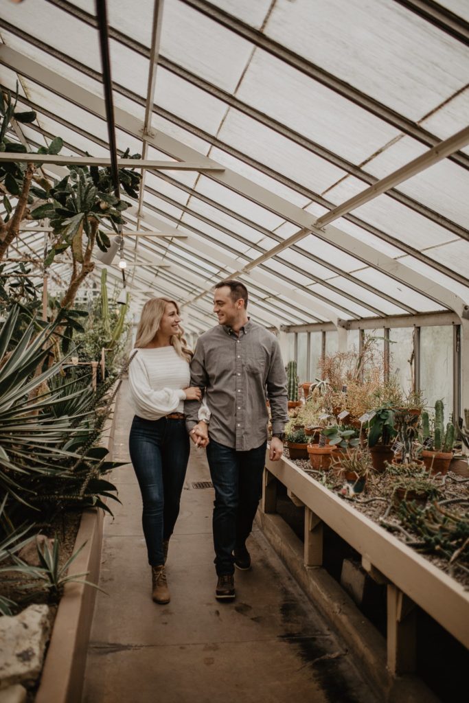 Couple holding hands and walking around the Buffalo Botanical Gardens
