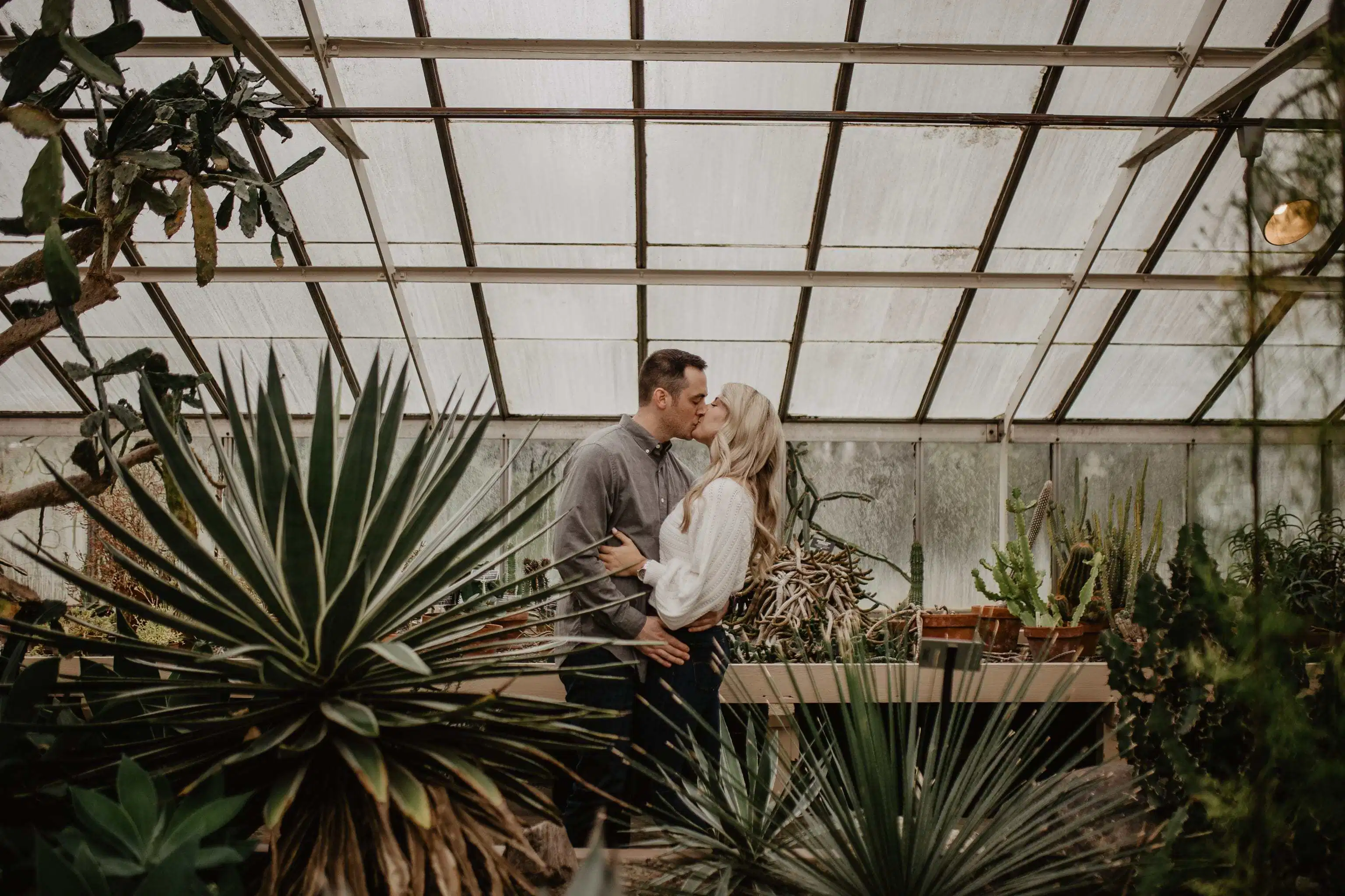 Close up of couple standing and kissing in a greenhouse in Buffalo, NY