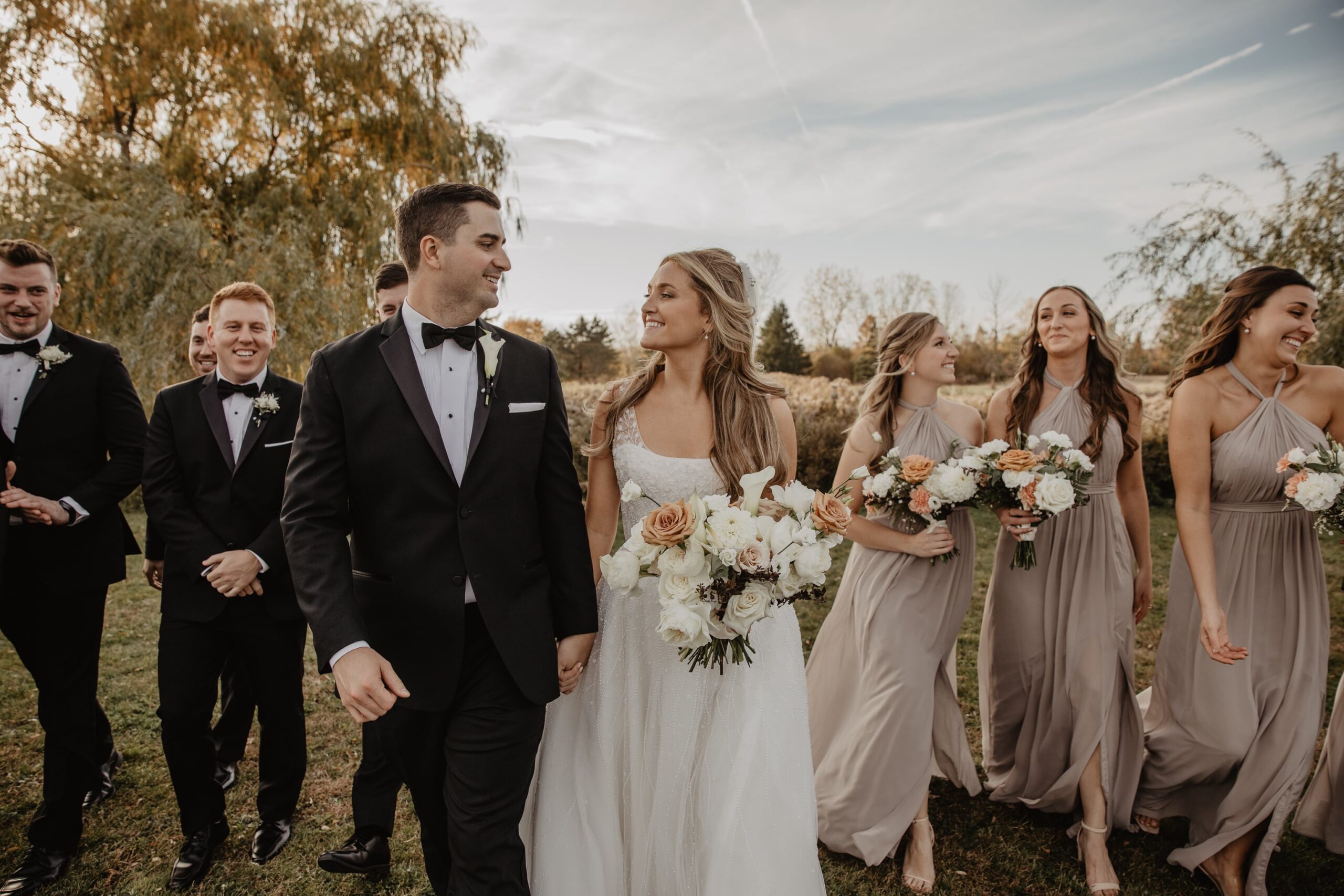 Newlywed husband and wife walk with their wedding party at The Sterling wedding venue, photographed by Buffalo Wedding Photographer Jessy Herman Photo