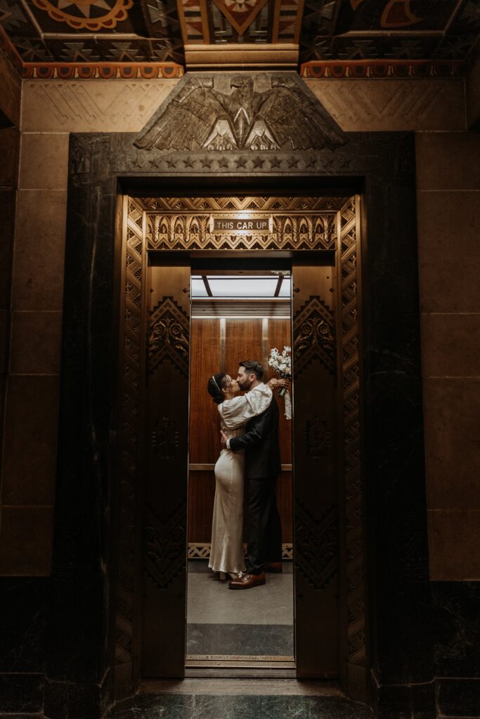 Bride and Groom kissing in elevator after getting married at Buffalo City Hall photographed by Jessy Herman Photo
