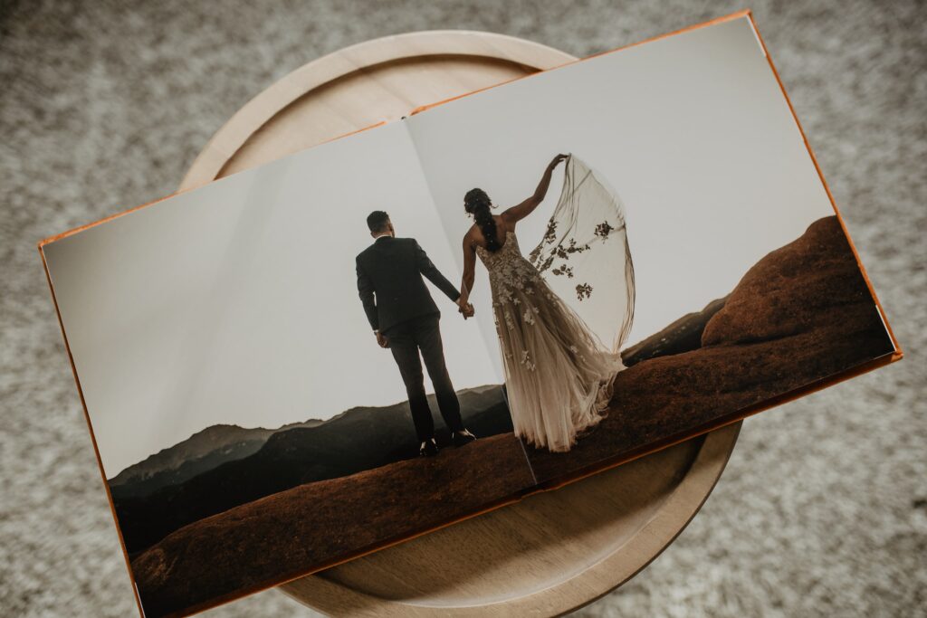 Image of an open heirloom wedding album with a full spread photo of a bride and groom elopement image