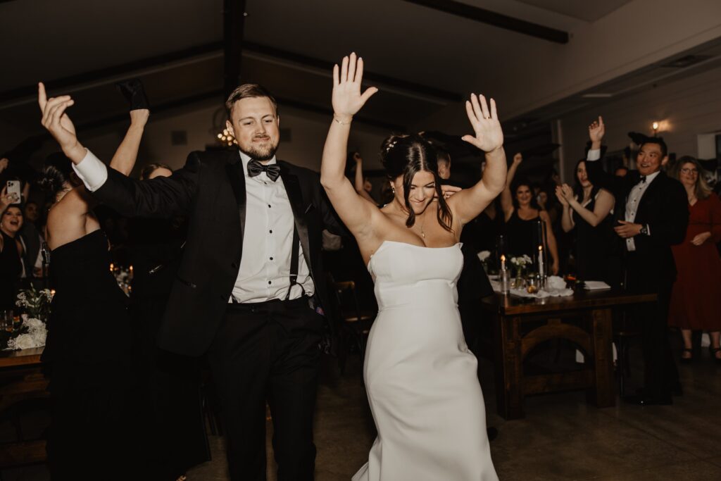 Bride and Groom enter the room while guests cheer