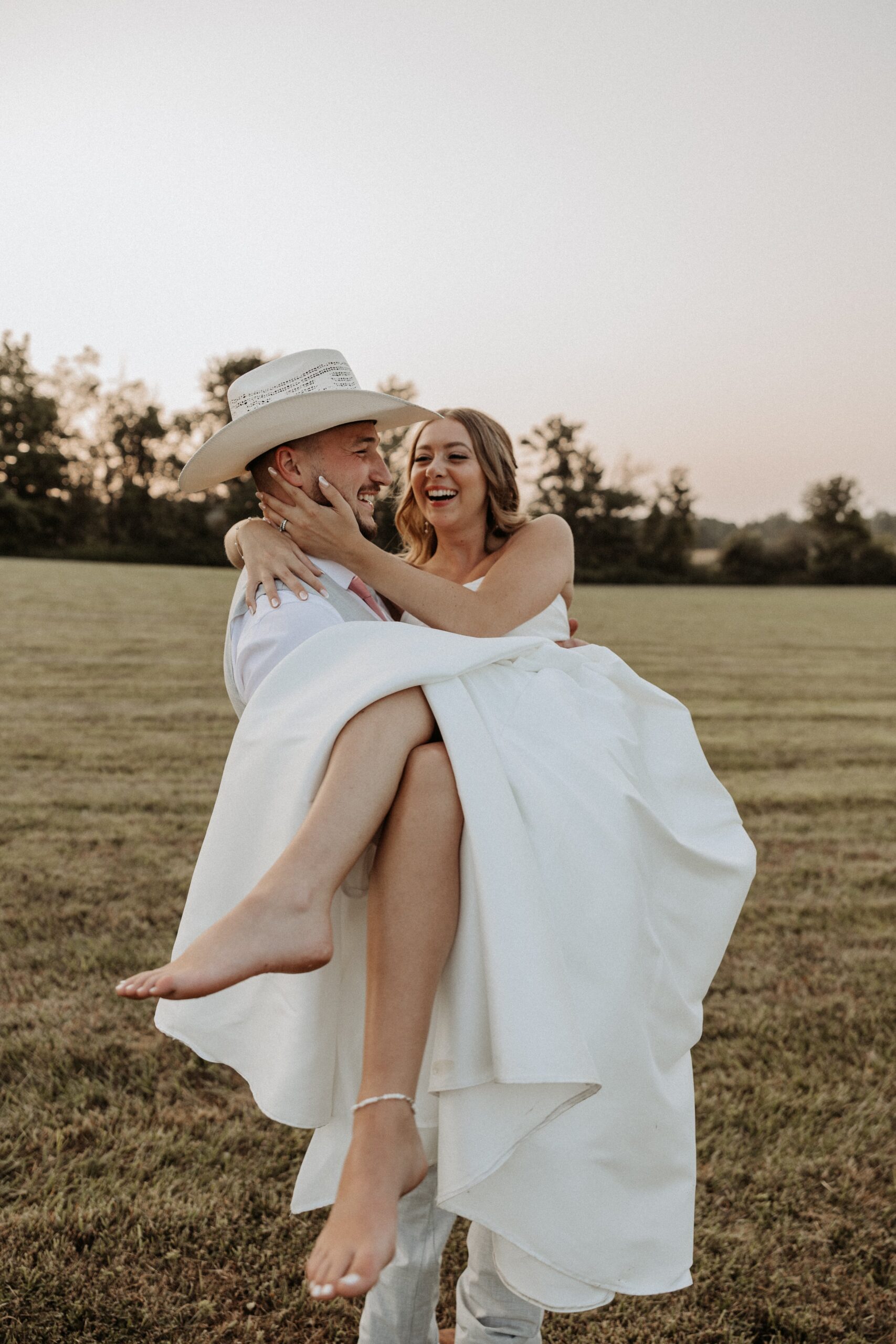 Barefoot bride and groom laughing during sunset portraits at Notting Hill Farm photographed by Jessy Herman Photo