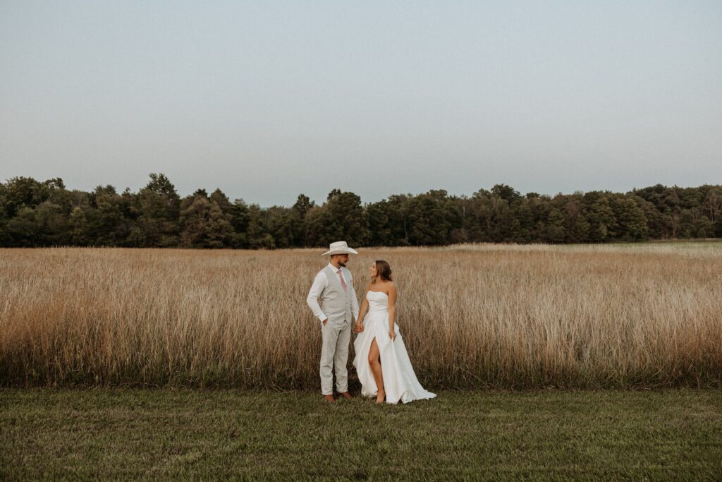 Bride and Groom at sunset in front of a tall field at Notting Hill Farm Wedding Venue in Wales, NY